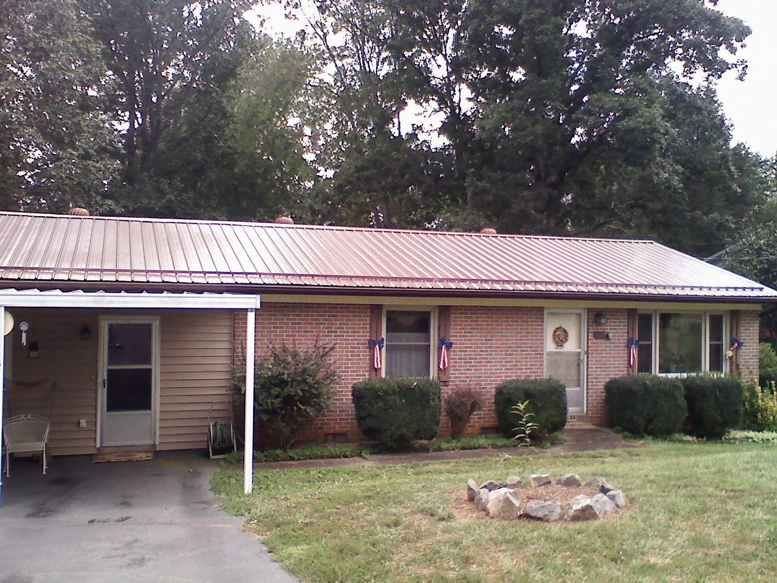 Bronze metal roof and carport on a brick ranch home — Roof Repair work by our crew in Gilchrist
