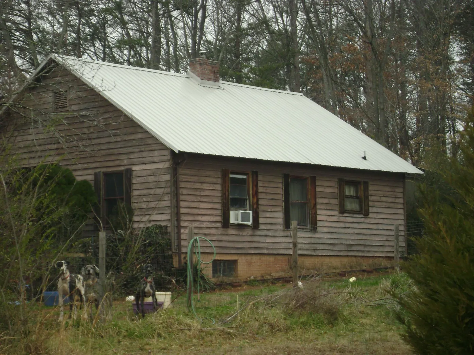 White metal roof on an old wood sided farmhouse, from a Metal Roof Installation job in Gilchrist